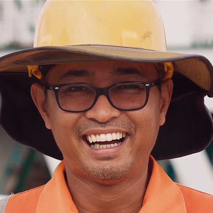 Headshot of a male employee at Toll wearing a hat and glasses