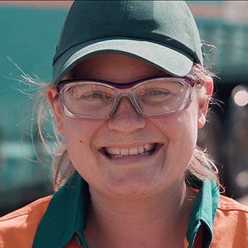 Headshot of a female Toll employee with a baseball hat and glasses